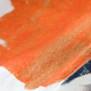 Close-up of a burnt orange brushstroke meeting charcoal.